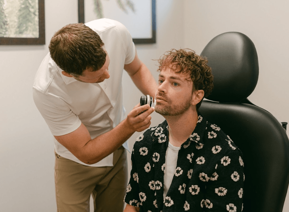 Dermatologist examining a patient's skin with a dermatoscope